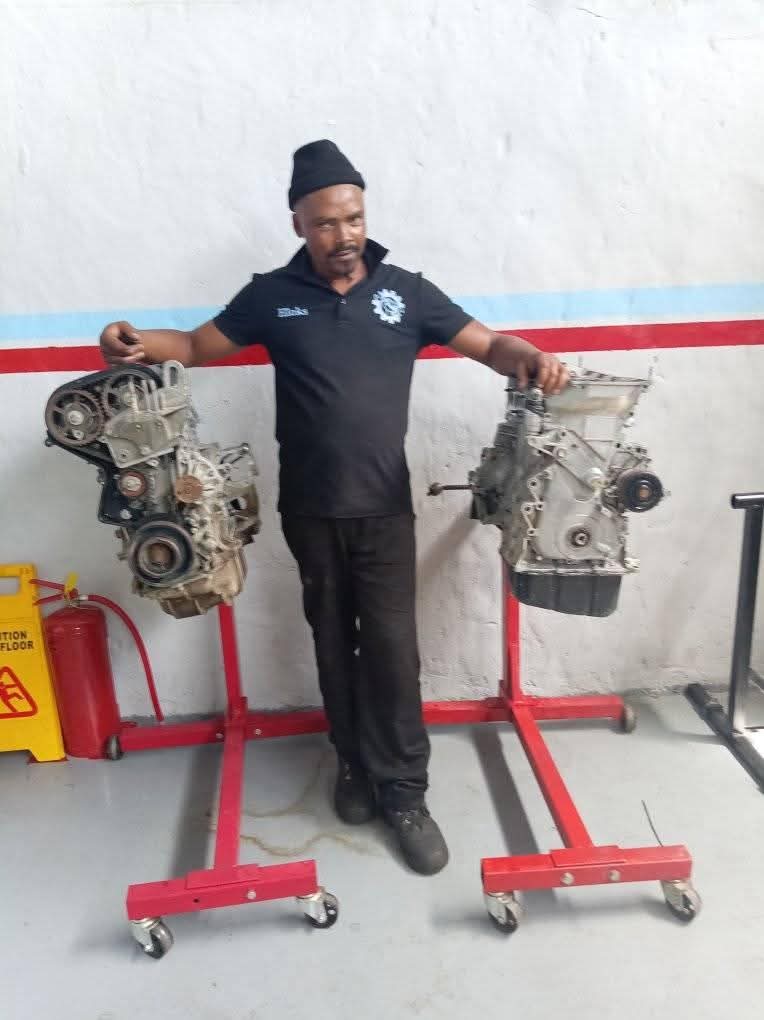 Artisan with engine blocks on training stands